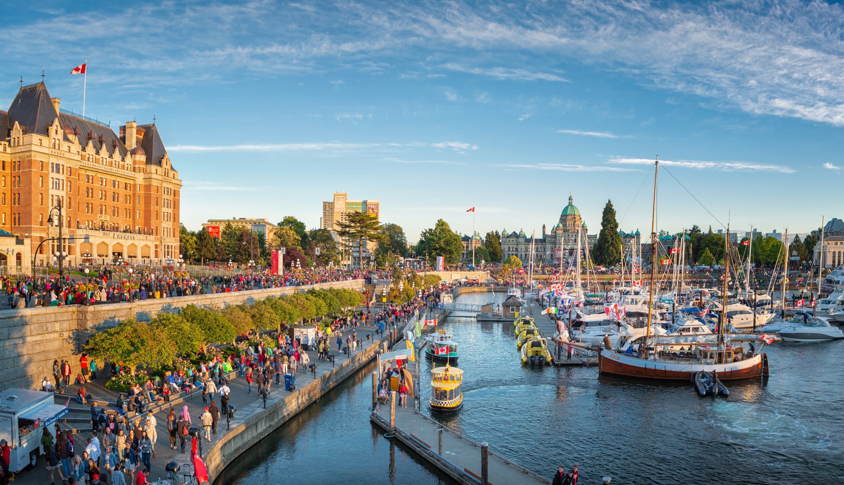 Victoria Harbour Masses of people visiting the celebrations at the Inner Harbour with the parliament building during sunset.