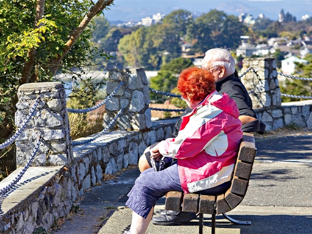 Two glasses of white wine on table with vineyard in background